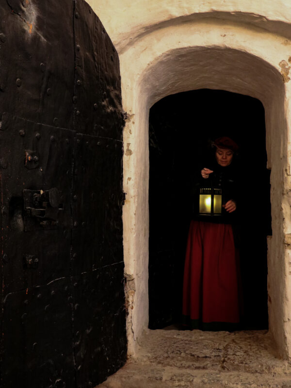 Guide på Kalmar Slott kommer ut ur ett mörkt rum