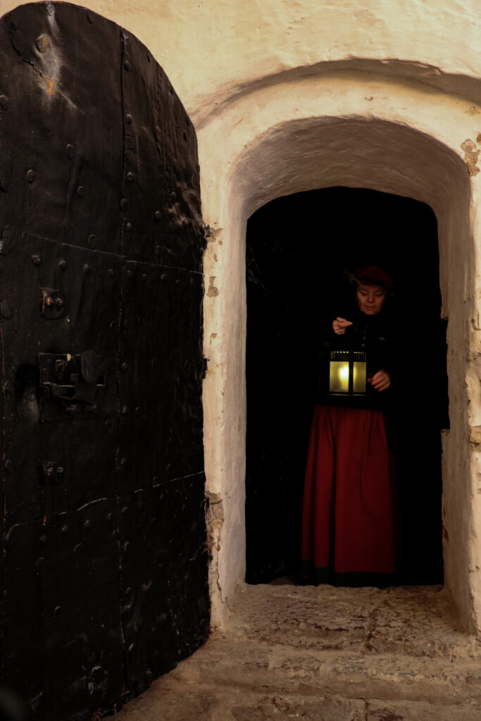 Guide på Kalmar Slott kommer ut ur ett mörkt rum