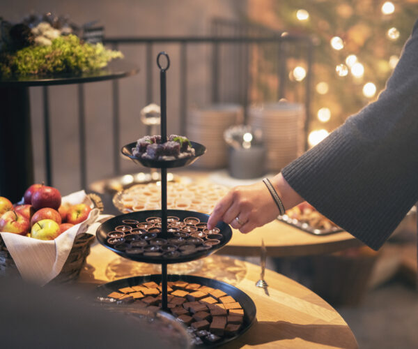Hand sträcker sig efter julgodis på ett bord.