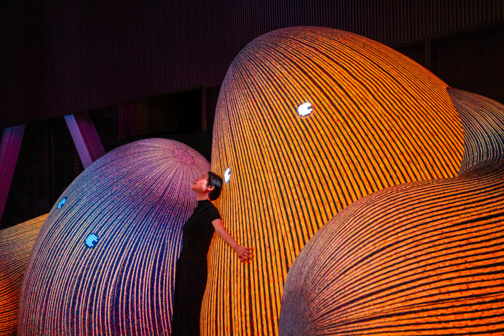 Person lutar sig mot mjuka färgglada stenar med ögon