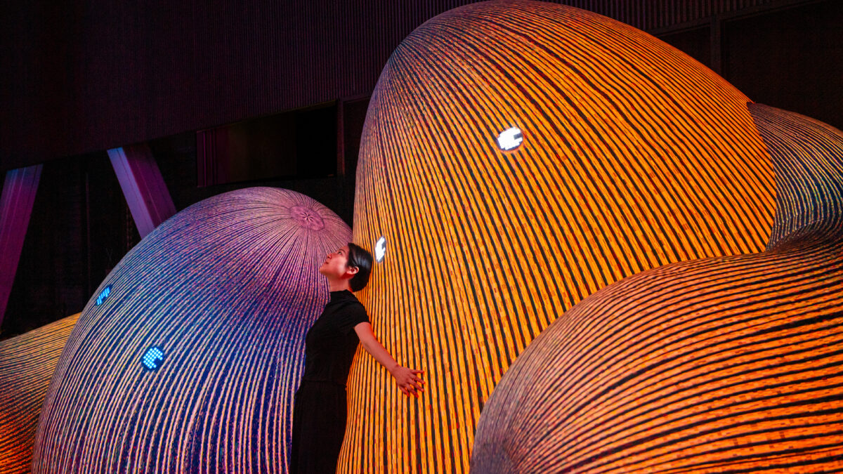 Person lutar sig mot mjuka färgglada stenar med ögon