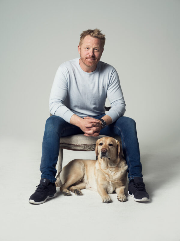 Fredrik Steen på stol med hund på golv