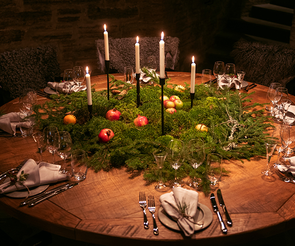 Runt bord dukat med granris och levande ljus
